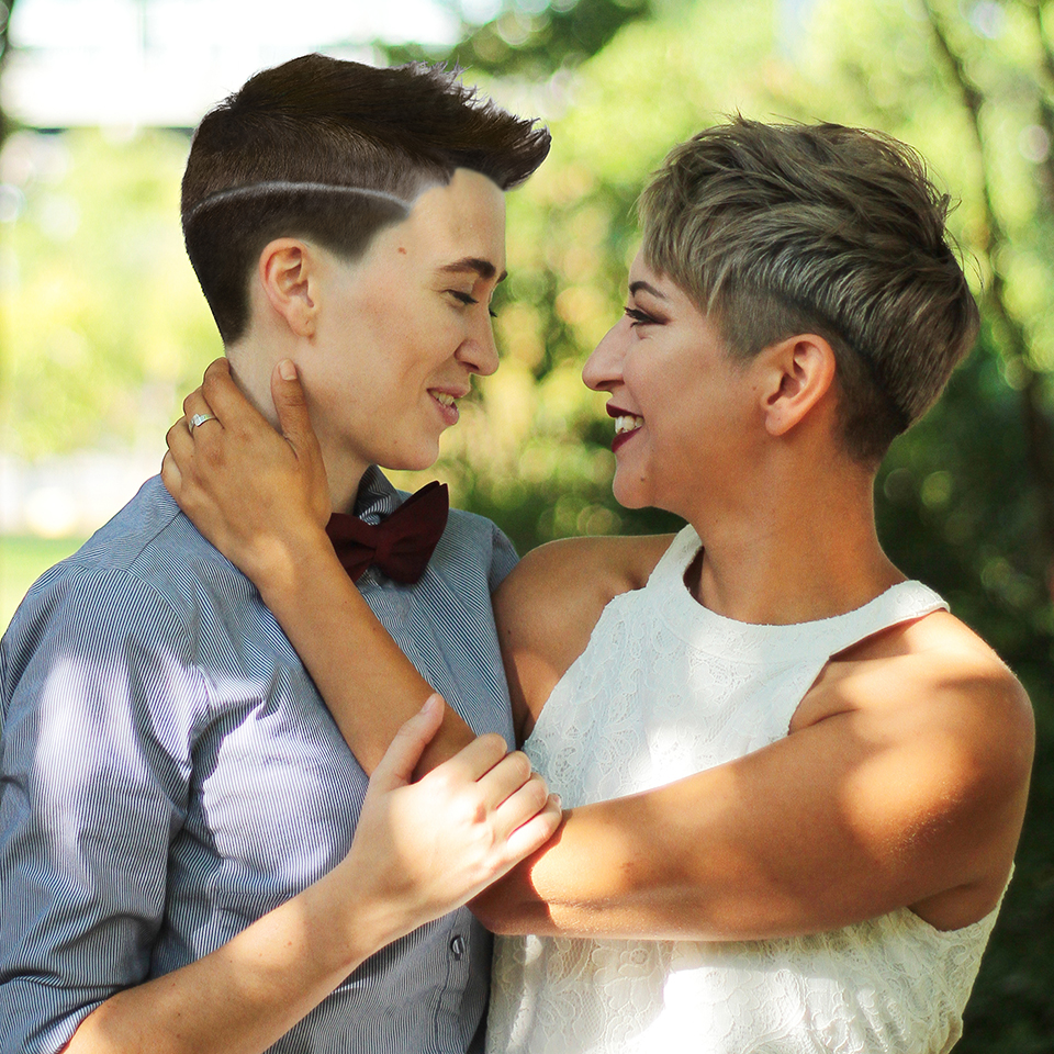 A couple smiles and embraces.