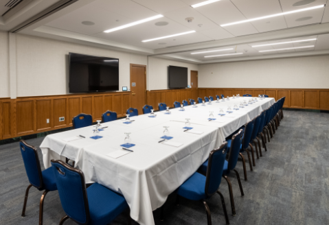 Large meeting room with long table, seating for 30 and audiovisual equipment.