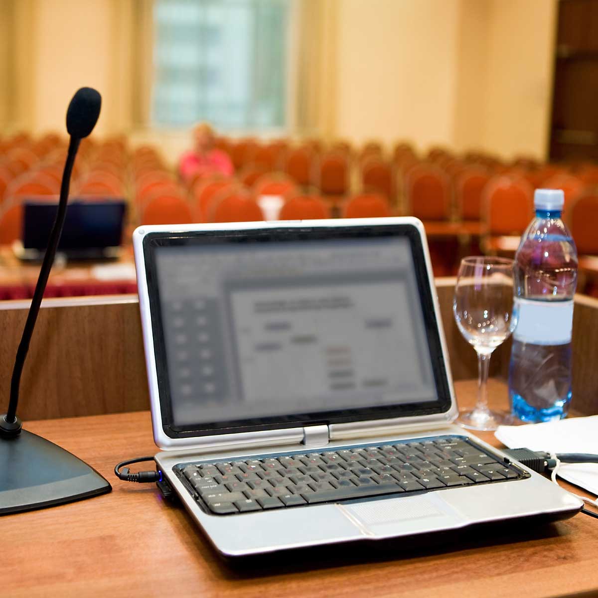 A laptop on a podium prepared for a presentation.